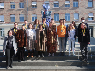 Schüler*innen stehen draussen auf einer Treppe vor einem Gebäude.