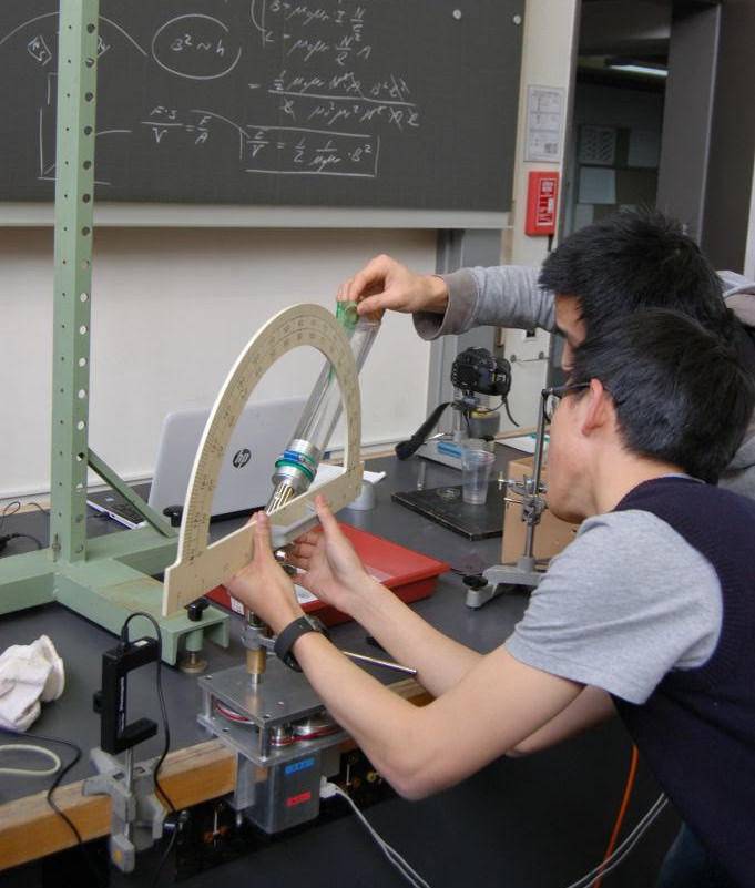 Zwei Schüler nehmen im Physiklabor Vermessungen vor.