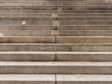 Eine steinerne Treppe, an einigen Stellen leicht kaputt. Frontal fotografiert, nur die Treppe ist zu sehen.