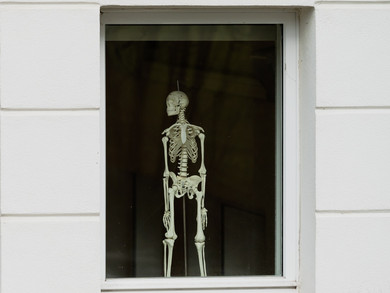 Skelett in einem Schulzimmer von aussen durchs Fenster fotografiert.