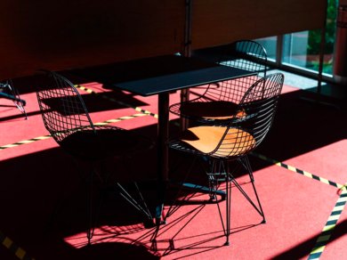 Stühle im Sonnenlicht auf einem roten Boden.