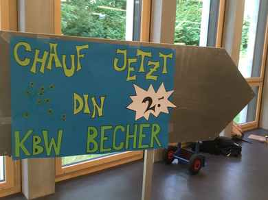 Kartonschild mit der Aufschrift «Chauf jetzt din KBW Becher»