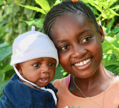 Schwarze lächelnde Frau mit Baby.