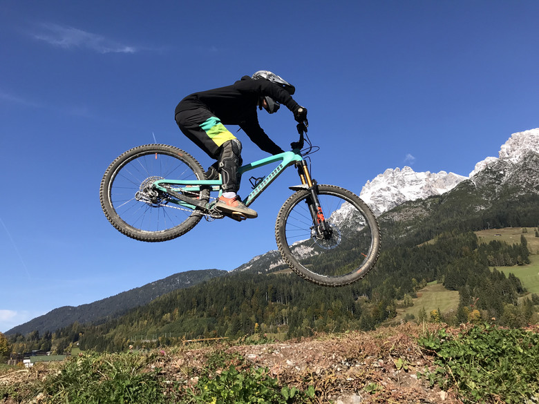 Ein Biker springt über einen Hügel.